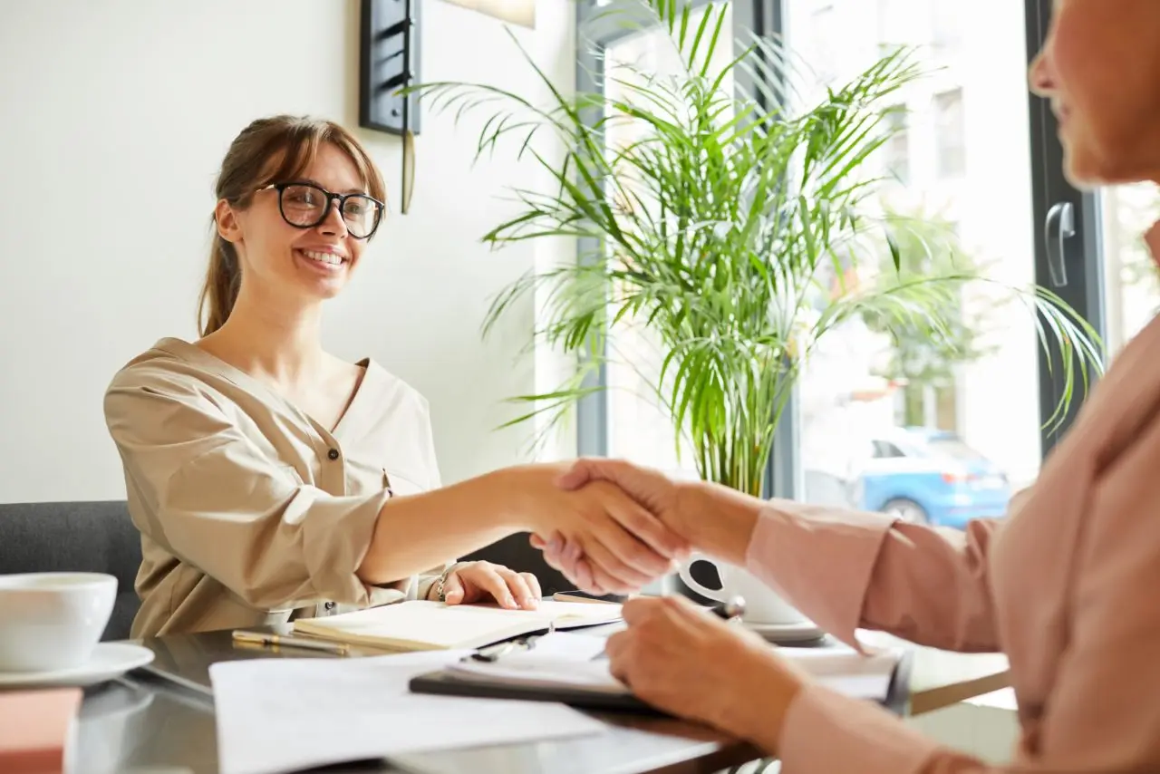Smiling woman shaking hands with lender